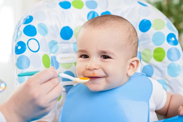 Adorável sorrindo bonito bebê comendo purê — Fotografia de Stock