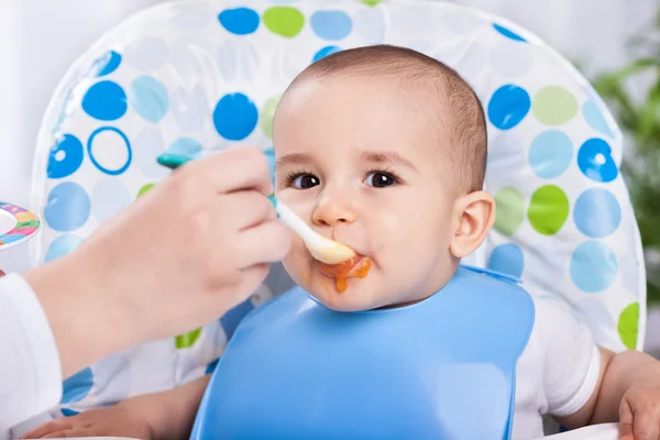 汚いかわいい赤ちゃんは食べ物を食べるときをお楽しみください。 — ストック写真