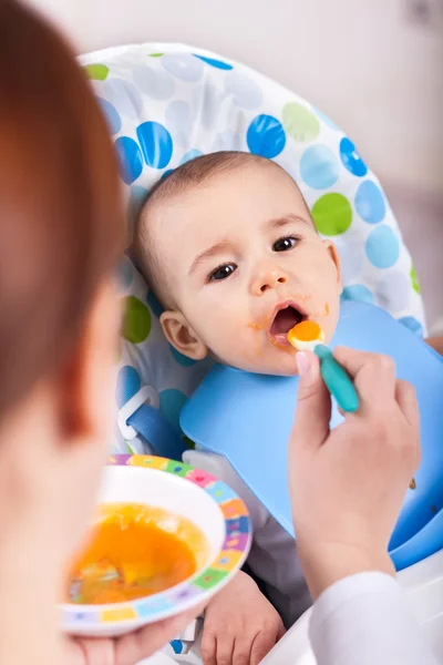 Miúdo bonito a dar uma dentada de comida — Fotografia de Stock