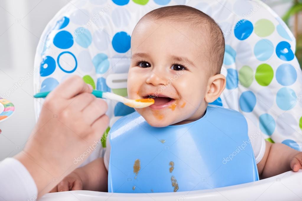 Smiling happy messy baby likes to eat