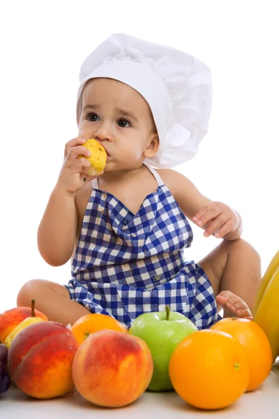 Grappige schattige baby met groene appels en verschillende vruchten — Stockfoto