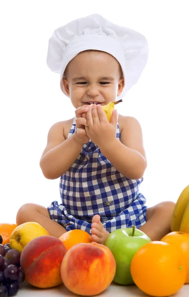 孩子戴着有健康食品水果的厨师帽的男孩 免版税图库图片