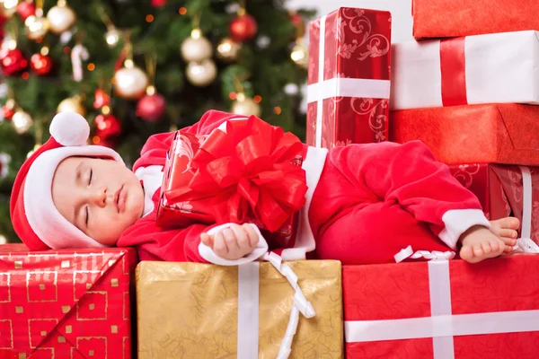 圣诞节的时候，可怜的小孩睡觉，拿着礼物 免版税图库照片