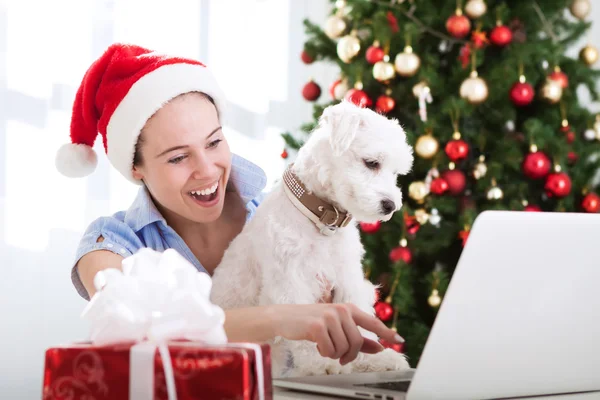 Lachende vrouw met hond op zoek naar computer en verrast — Stockfoto