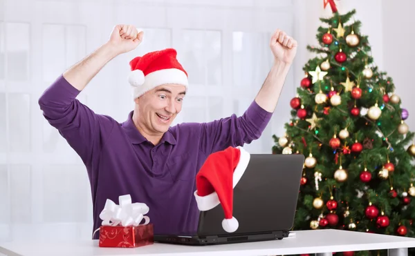 Feliz hombre mayor sonriente con Santa Claus sombrero de compras en línea —  Fotos de Stock