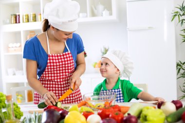 Mutlu sevimli oğlu ile güzel Annem akşam yemeği için yemek hazırlamak