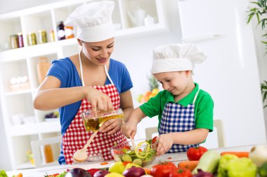 Anne ve çocuk sebze marul için zeytinyağı koyarak