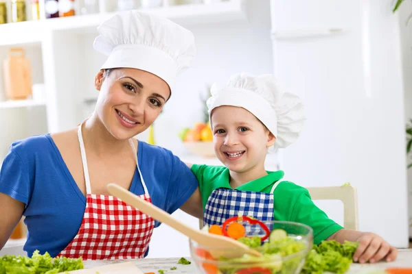 Mutlu anne ve çocuk şef şapkasını ile gülümseyen