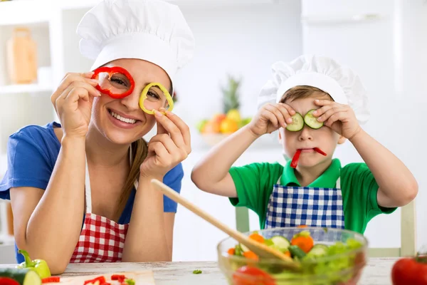 Happy cute keluarga bersenang-senang di dapur dengan sayuran — Stok Foto