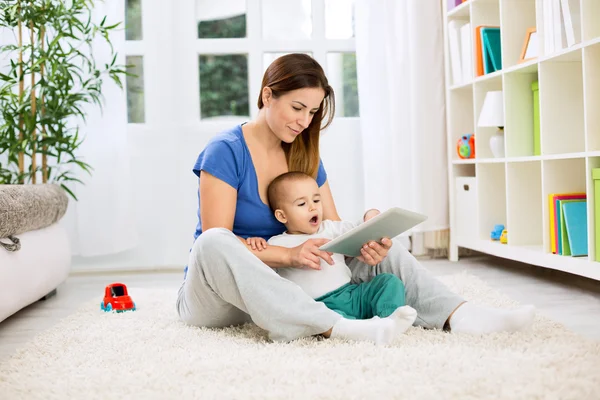 Happy smiling mother and child playing on tablet — Stock Photo, Image
