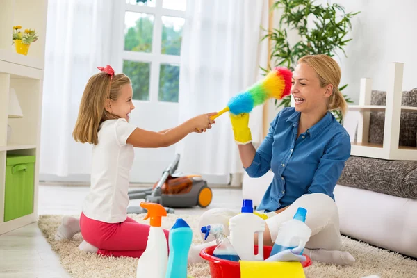 Senyum wanita dan anak perempuan menikmati membersihkan rumah — Stok Foto