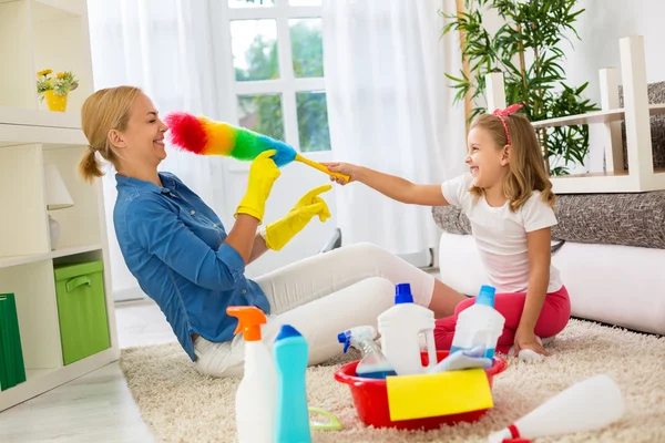 Smiling happy family playing with cleaning tool — Stock Photo, Image