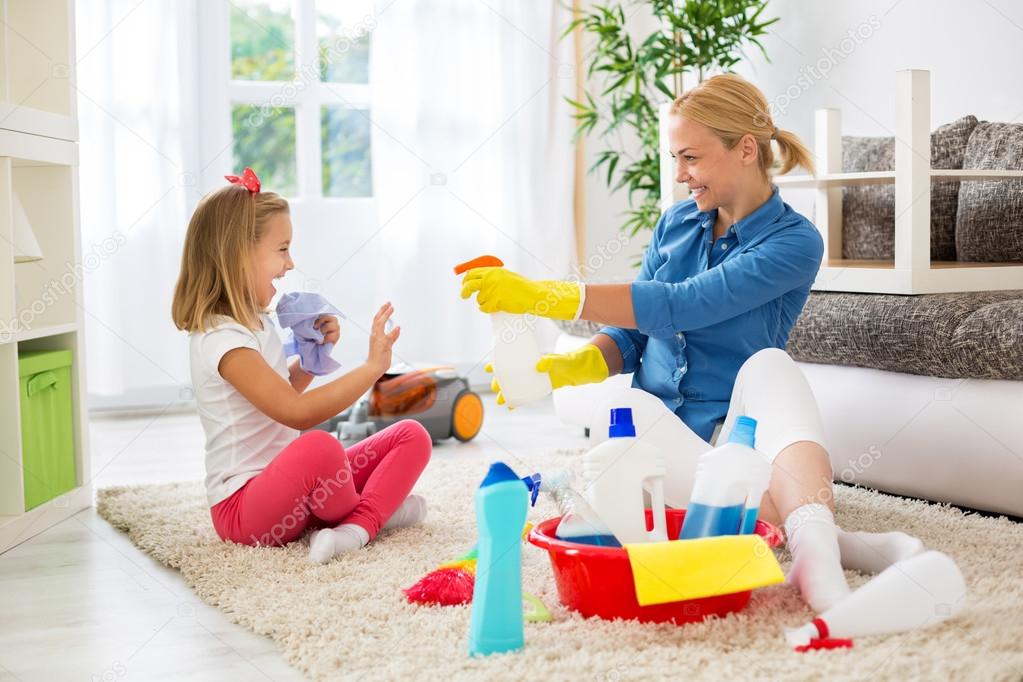 Mother and little girl cleaning house and playing