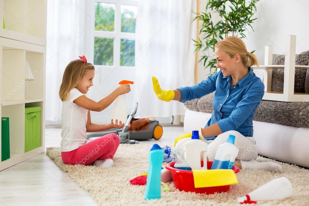 Mother and child cleaning home and having fun