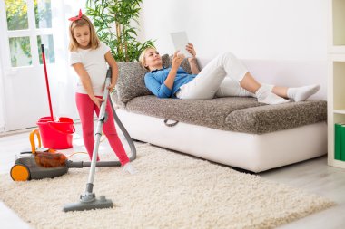 Tembel anne tablet üzgün kız ev temizliği sırasında kullanma