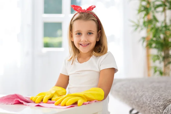 Stojí za to s úsměvem mladá dívka s rukavicemi čištění domů — Stock fotografie