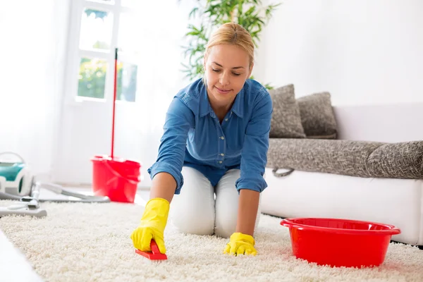 Alfombra de limpieza de ama de casa con cepillo y haciendo tareas domésticas — Foto de Stock