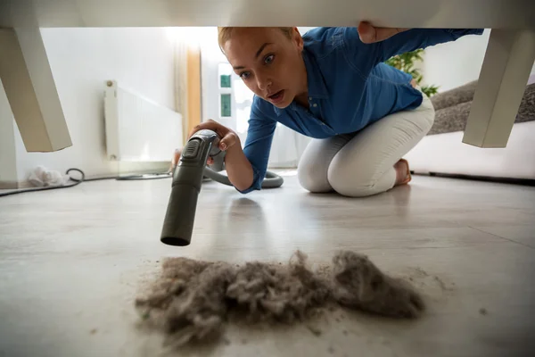 Ibu rumah tangga yang terkejut menemukan debu di bawah furnitur — Stok Foto