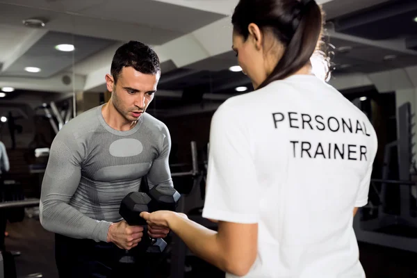 Treinadora fazendo exercícios com sua cliente — Fotografia de Stock