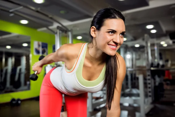 Sonriente joven ejercicio en el club de gimnasia —  Fotos de Stock