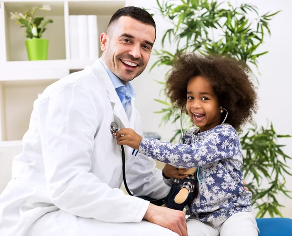 Pediatra sonriente y su pequeño y feliz paciente — Foto de Stock