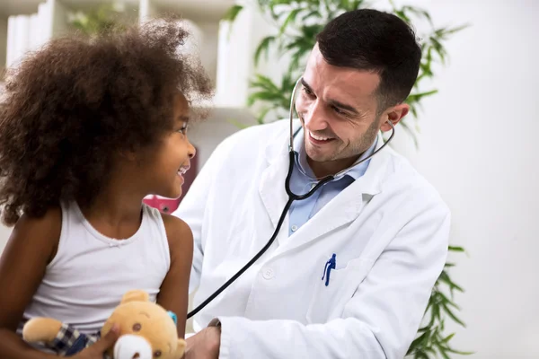 Позитивный врач-педиатр осматривает ребенка — стоковое фото