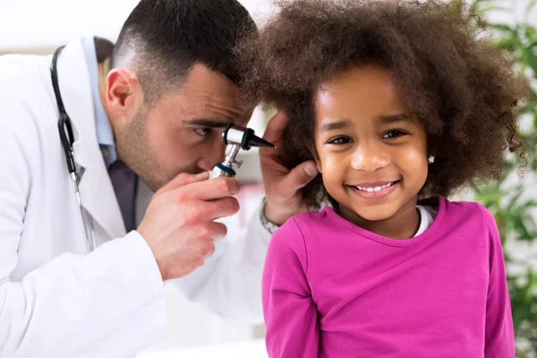 Sonriente niña africana con especialista en orejas — Foto de Stock