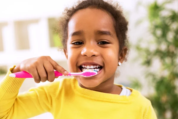 Piccola bella ragazza africana lavarsi i denti — Foto Stock