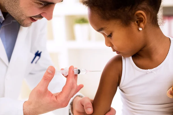 Médico inyectando vacuna a linda chica africana — Foto de Stock