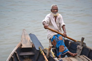Dhaka, Bangladeş - 4 Temmuz 2011: Tahta botlu, beyaz sakallı ve saçlı, Bangladeş 'in başkenti Dhaka' da bir nehirde