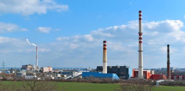 Endüstriyel arazi. Yüksek bacalardan duman çıkan termik santral. Ekolojik tehlike.