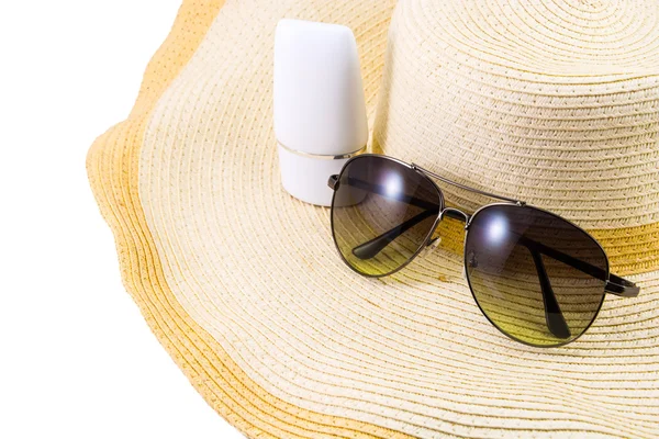 Zonnebril en zonnebrandcrème op hoed — Stockfoto