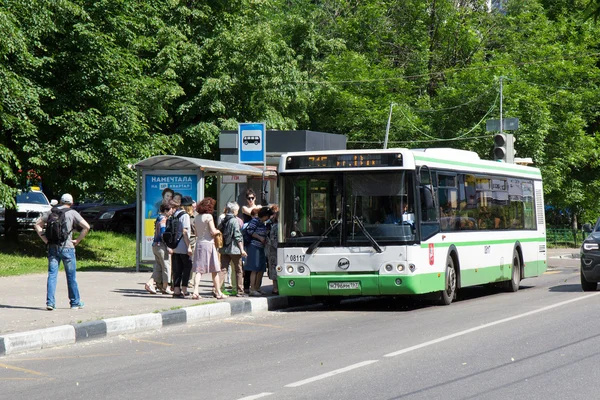 Ônibus verde na parada de ônibus na rua da cidade de Moscou Fotos De Bancos De Imagens
