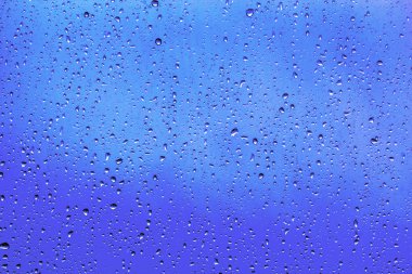 Mavi cam üstünde su damlaları