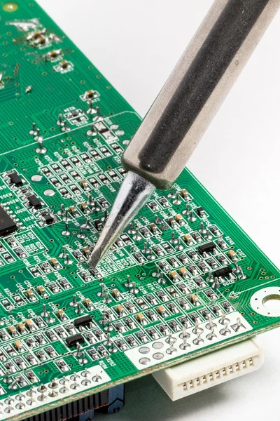 Blade of solderer under electronic board — Stock Photo, Image