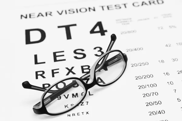 Glasses on eye chart — Stock Photo, Image