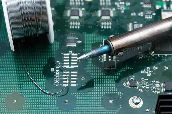 Soldering-iron on a PCB — Stock Photo, Image