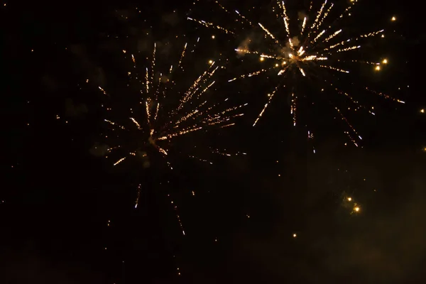 Kutlama gecesi, kara gökyüzünde patlayan altın havai fişeklerle