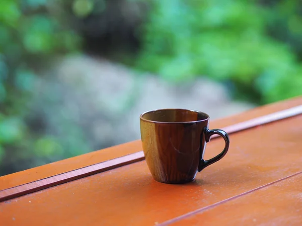 木制桌子上的褐色咖啡杯 背景模糊不清 — 图库照片