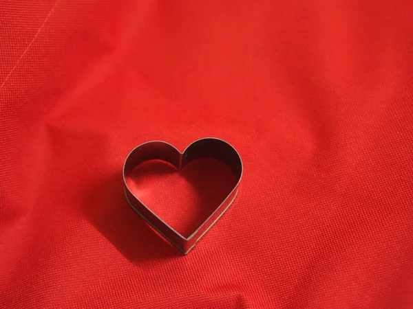 bread molds stainless Heart shaped on fabric red background, love Valentine Day for copy text card, background