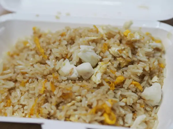 Crab meat fried rice topped with Scrambled egg, style Thai food, in white foam box