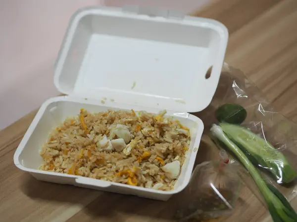 Crab meat fried rice topped with Scrambled egg, style Thai food, in white foam box