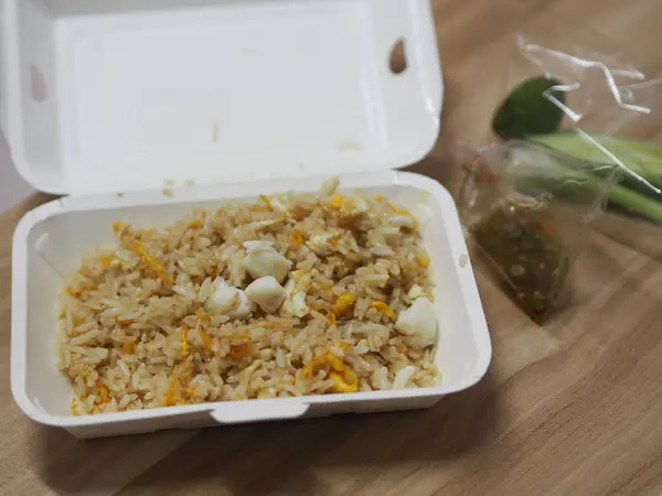 Crab meat fried rice topped with Scrambled egg, style Thai food, in white foam box