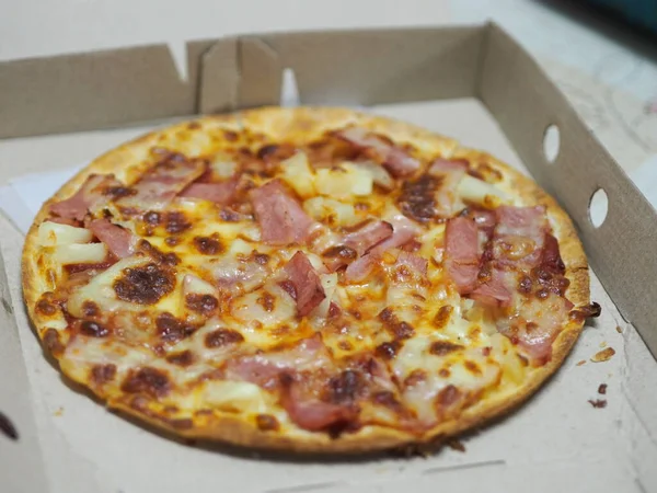 Pizza Hawaiian on top with Ham, Bacon, Pineapple and Pizza Sauce in paper box