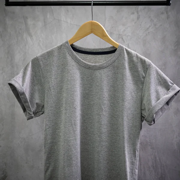 Young male in front blank black t-shirt Roll up sleeves template, Three color black white gray hang on cement background for your design mockup concept man tshirt product, woman shirt in fashion shop.