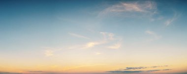 Minimalist panoramik arka plan, yumuşak sarı güneş ışığı ve şafak veya alacakaranlıkta ince bulutlar. Doğa, hava, özgürlük ya da ilham verici kavramlar için mükemmel..