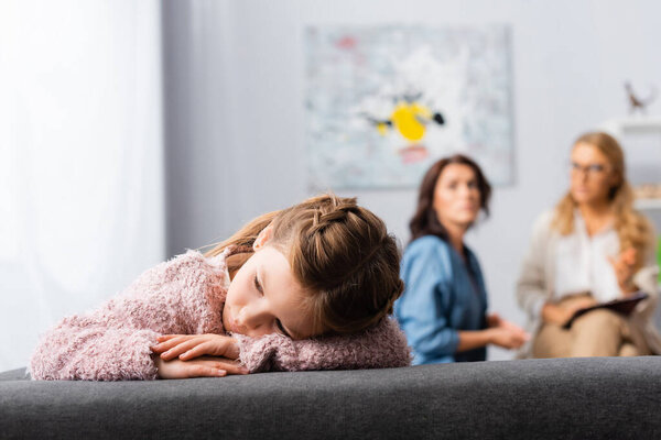 daughter getting bored while mother talking to psychologist