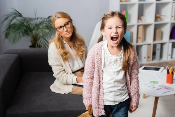 Menina Zangada Com Brinquedo Gritando Enquanto Visita Psicólogo — Fotografia de Stock