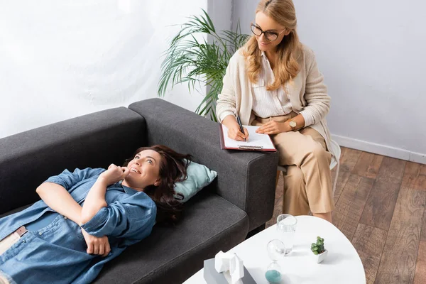 Glückliche Brünette Frau Liegt Auf Dem Sofa Während Sie Den — Stockfoto