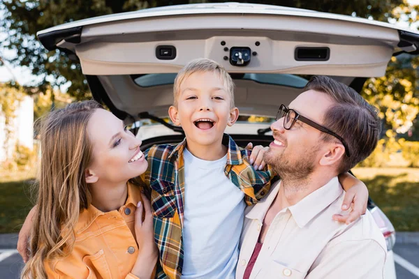 Sonrientes Padres Mirando Niño Cerca Auto Sobre Fondo Borroso Aire — Foto de Stock